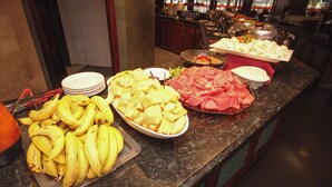 Un bufé con diferentes frutas y carnes.