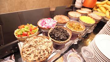 Buffet-pöydässä on tarjolla monenlaista ruokaa, kuten salaatteja, lihaa ja jälkiruokia.