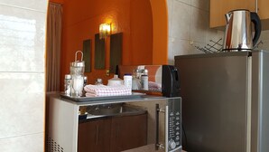Une petite cuisine équipée d’un four à micro-ondes, d’une bouilloire et d’une machine à café.