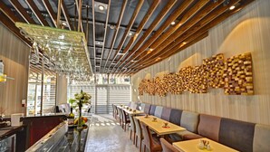 A modern restaurant interior with a long counter, seating area, and a decorative wall. - All Inn Hotel (Istanbul)