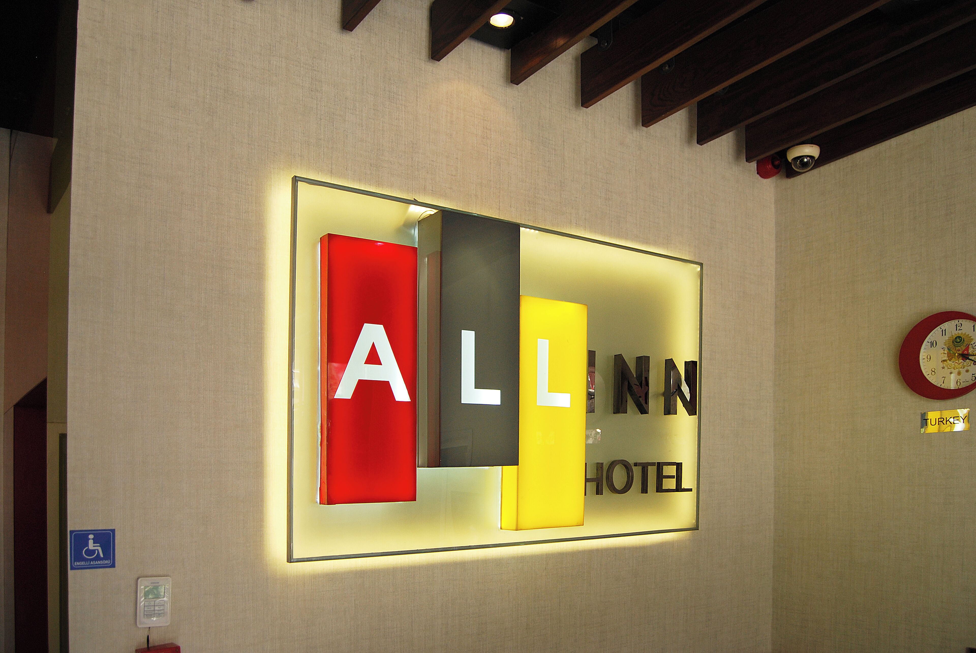 A hotel sign with the name "ALL INN HOTEL" in illuminated letters.