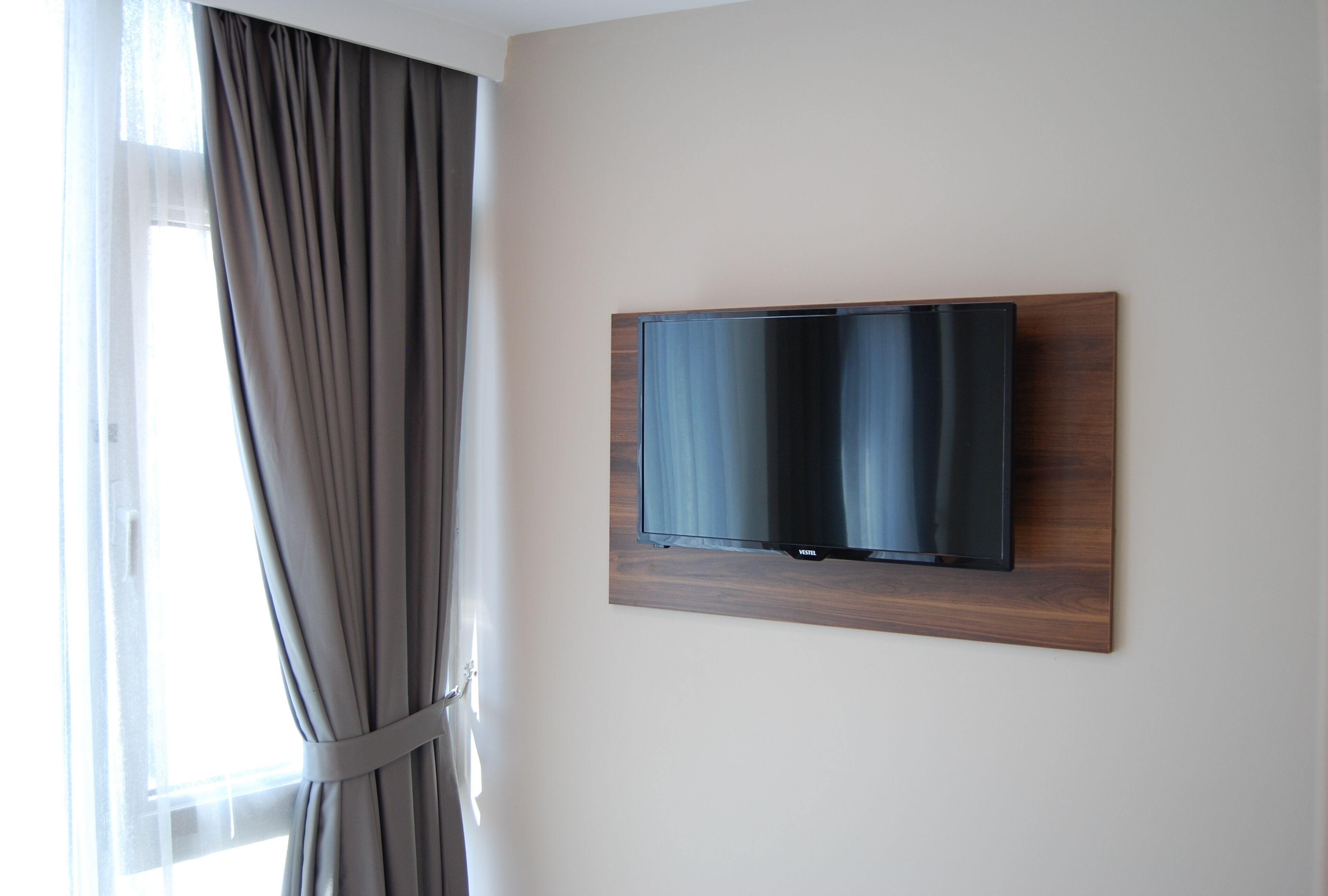 Een flatscreen televisie bevestigd aan een muur met een houten lijst.