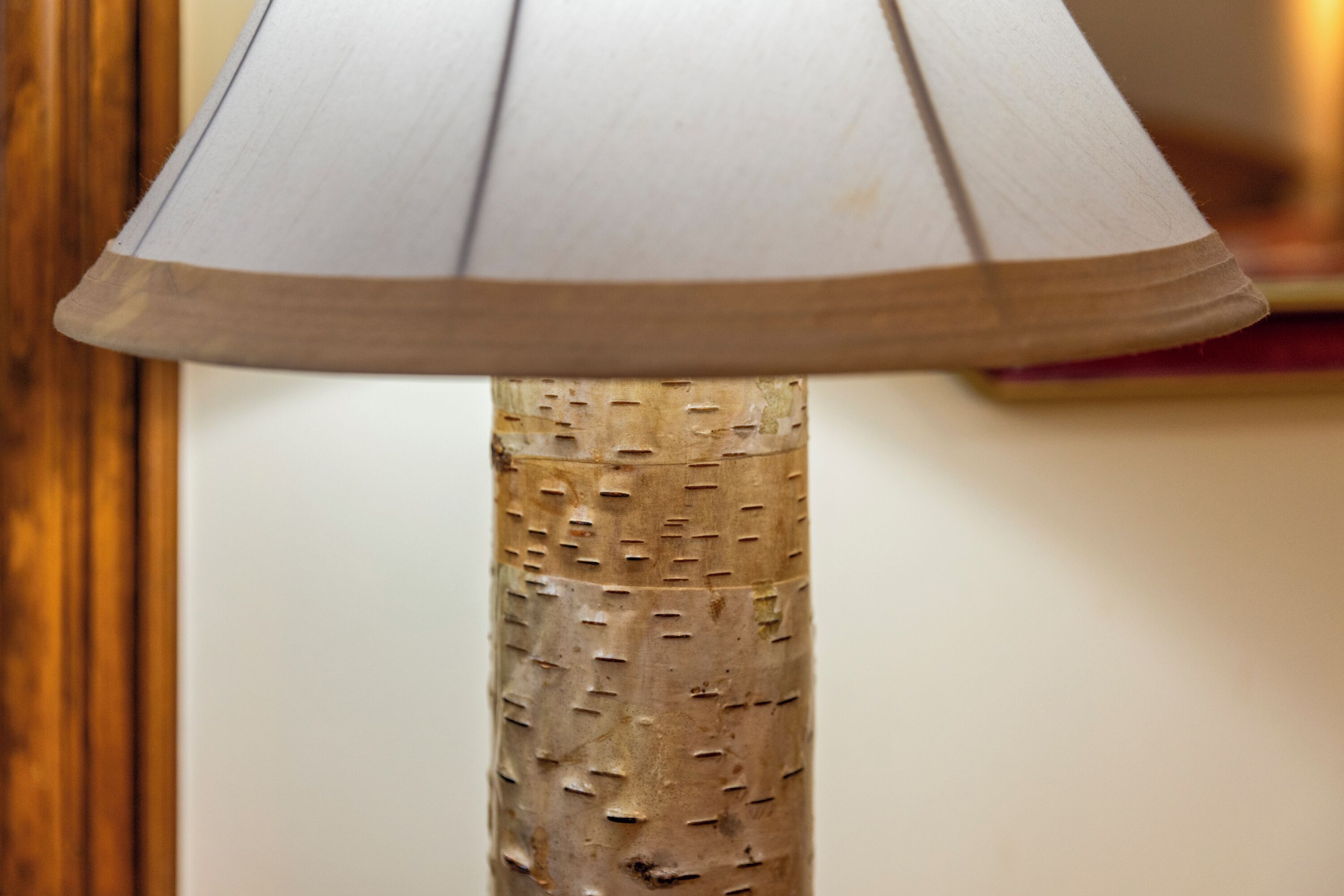 A lamp with a textured wooden base and a conical shade.