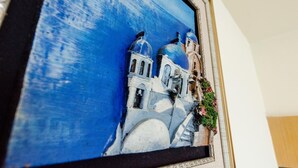 Un tableau encadré représentant un bâtiment doté de coupoles, avec un ciel bleu en arrière-plan.