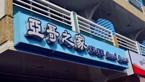 Une enseigne d’hôtel avec des caractères chinois et le nom « Yake Beach Resort ».