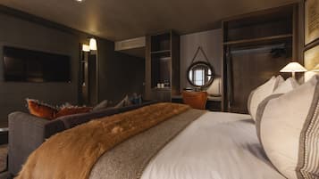 Ein modernes Hotelzimmer mit einem großen Bett, einem Schreibtisch, einem Fernseher und einem Spiegel.