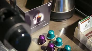 Uma máquina de café com manual e vários tipos de cápsulas de café em uma bancada.