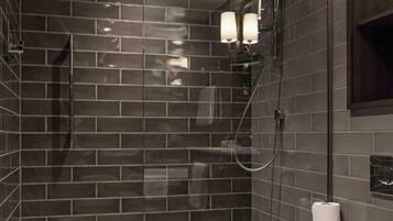 A modern bathroom with a glass-enclosed shower, a toilet, and a wall-mounted towel rack.