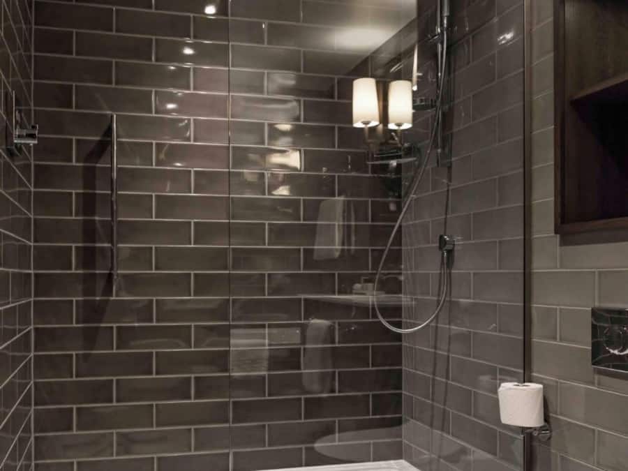 Een moderne badkamer met een douchecabine van glas, een toilet en een handdoekhouder aan de muur.