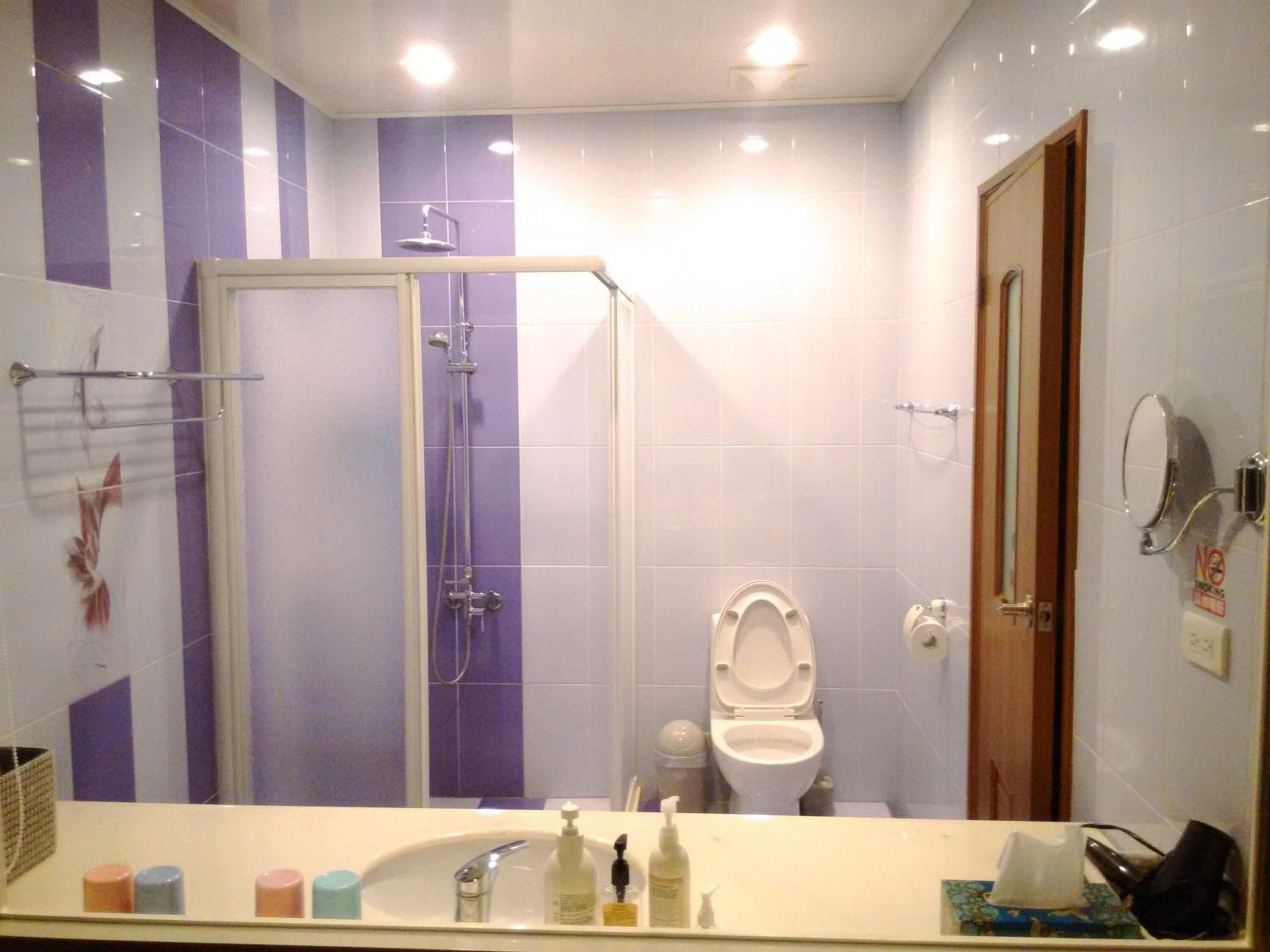A bathroom with a shower, toilet, and sink.