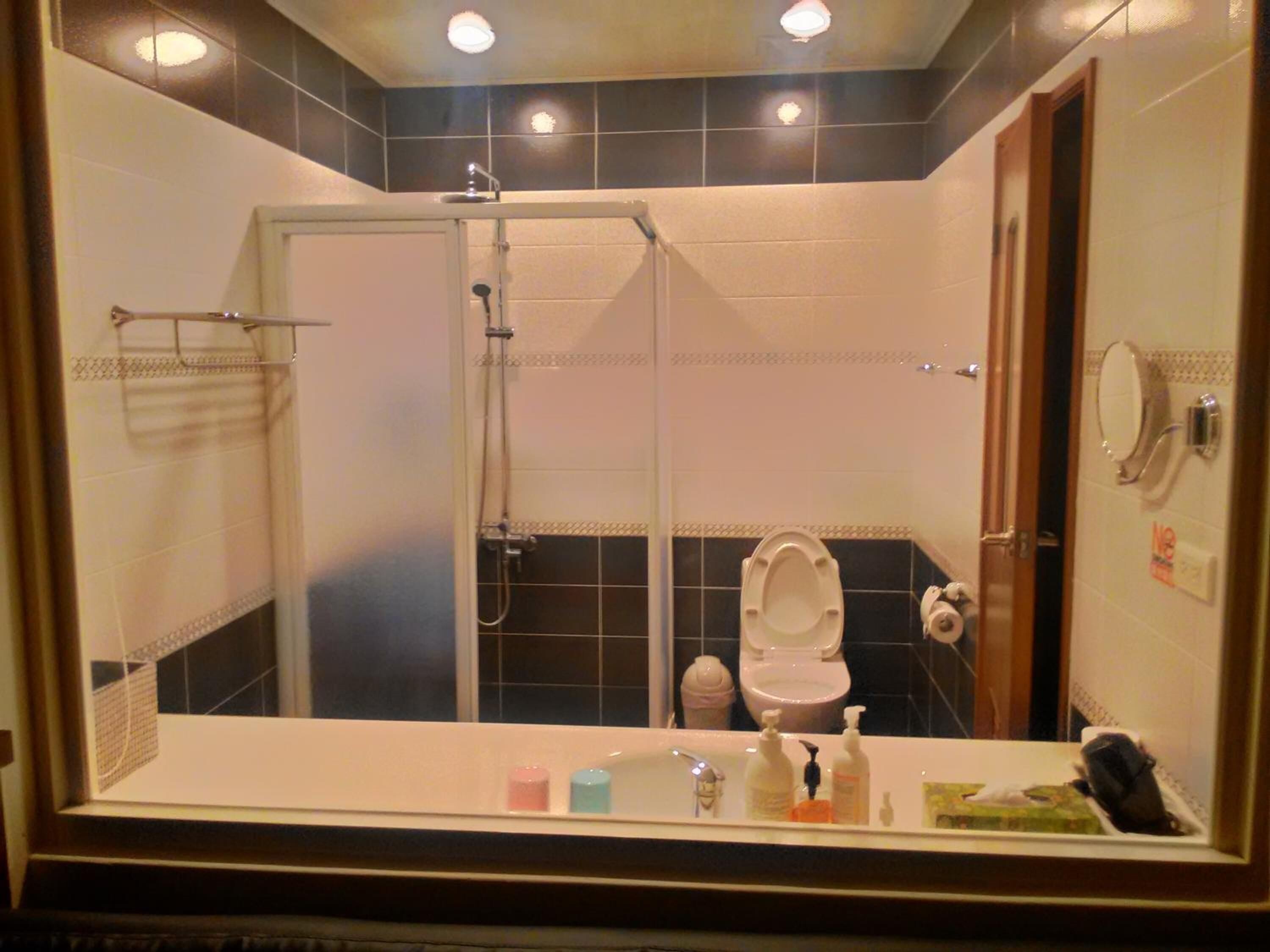 A bathroom with a shower, toilet, and sink.