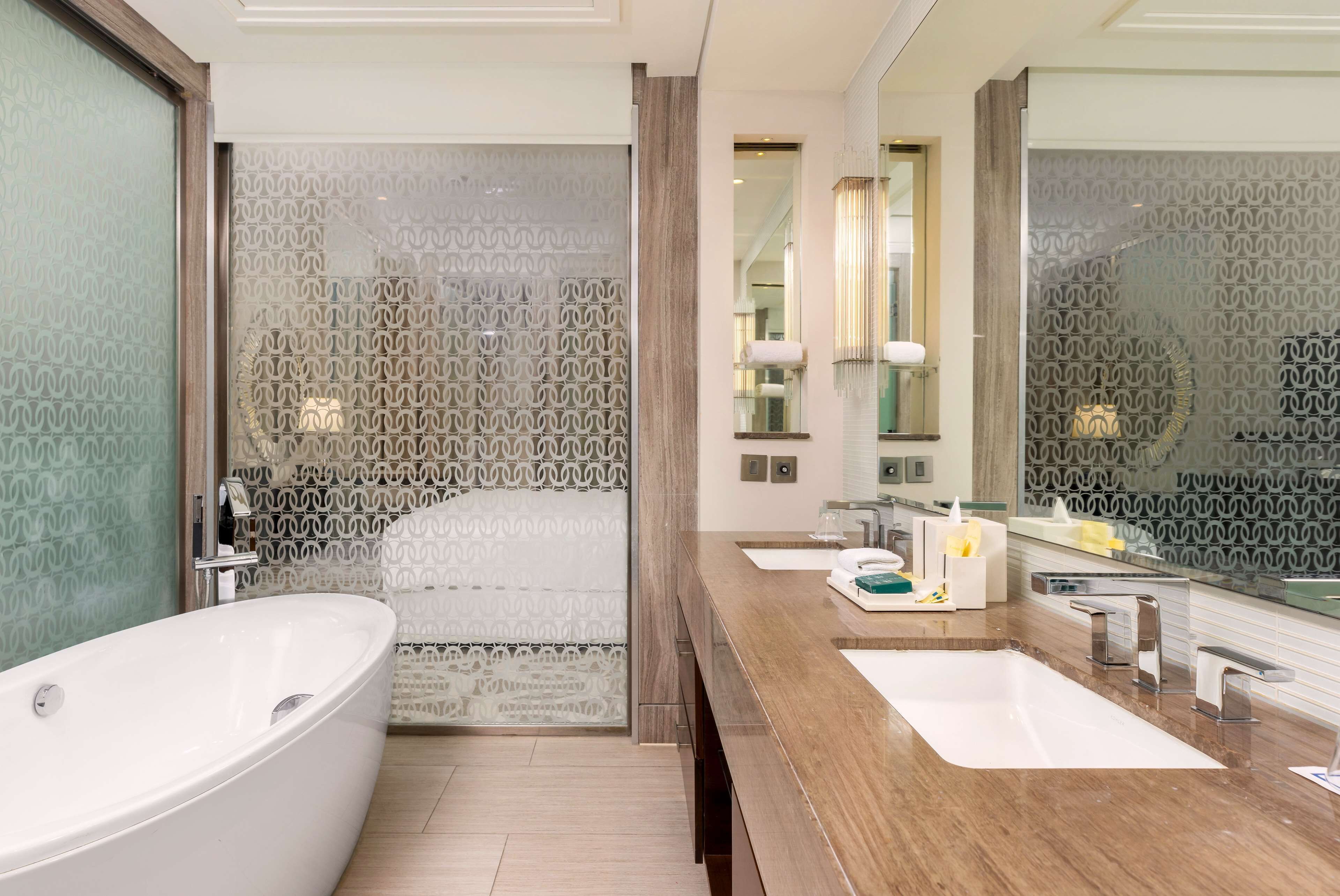 A modern bathroom with a freestanding bathtub, a vanity with a mirror, and a shower area.