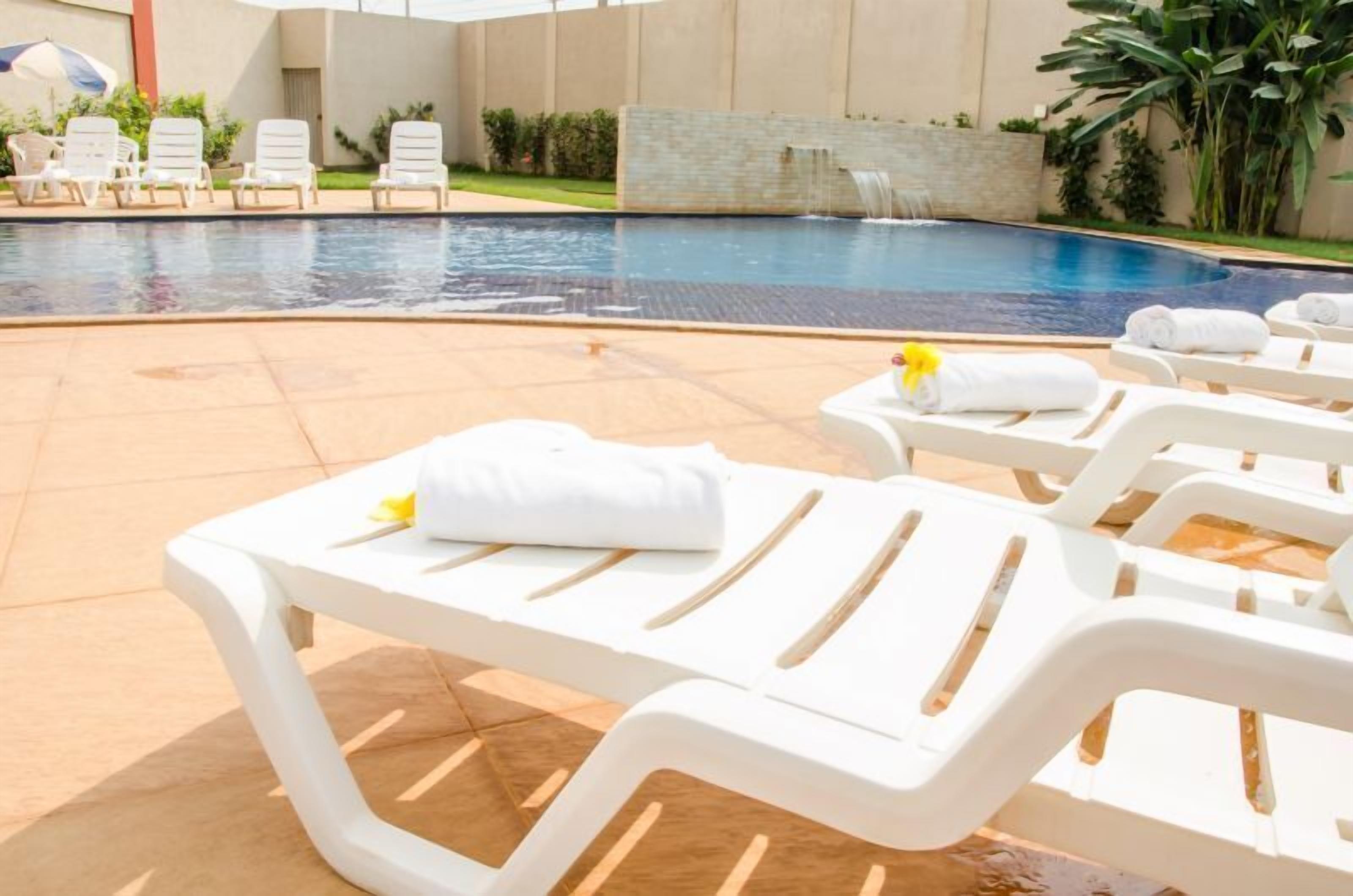 Una piscina al aire libre, tumbonas