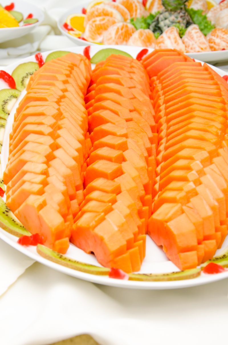 A plate of sliced fish, possibly salmon, arranged neatly on a white plate with a decorative border.