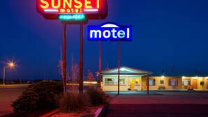 A motel sign with neon lights, a neon sign indicating 'SUNSET motel since 1959', and a blue sign with the word 'motel'. - Sunset Motel (Moriarty)