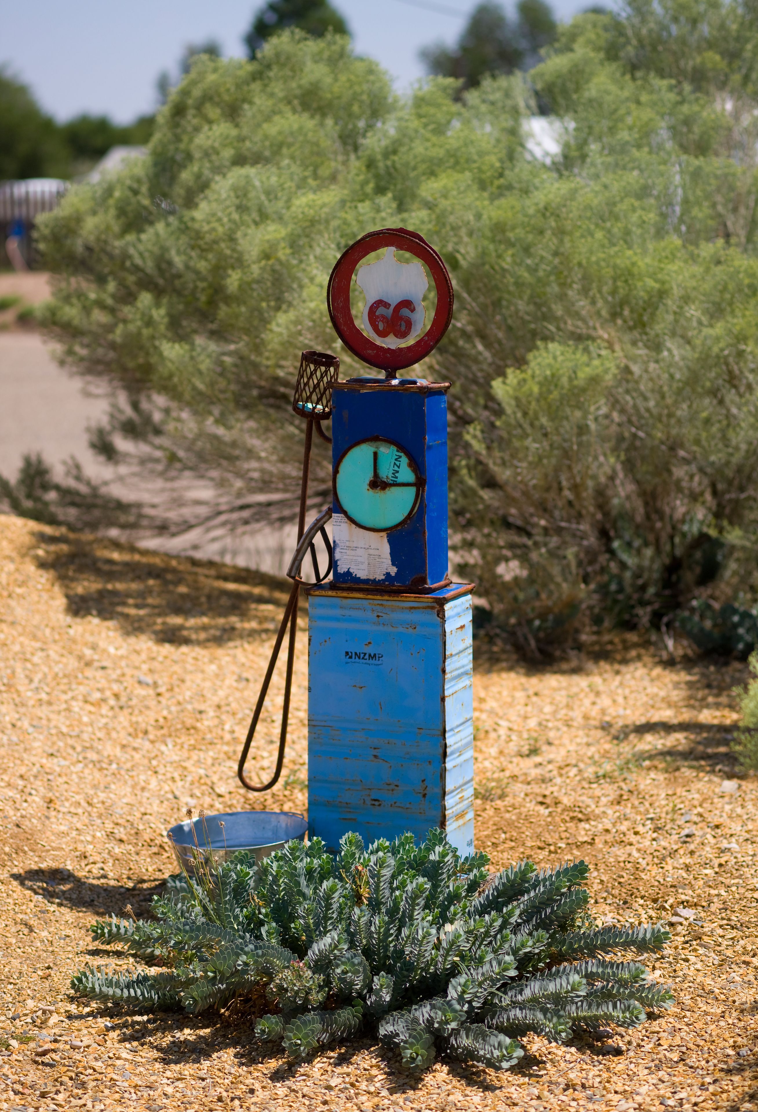 Eine blaue Zapfsäule mit einer Uhr und einem Geschwindigkeitsbegrenzungsschild.