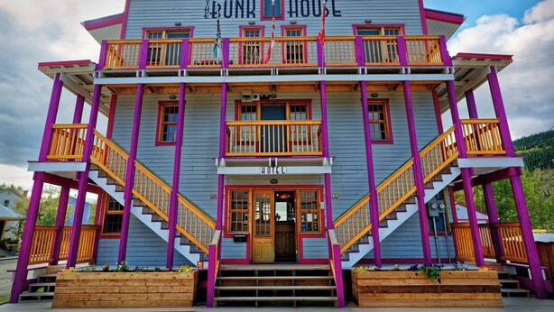 Un edificio de dos pisos con balcones y un letrero que dice "The Bunk House" en la fachada.
