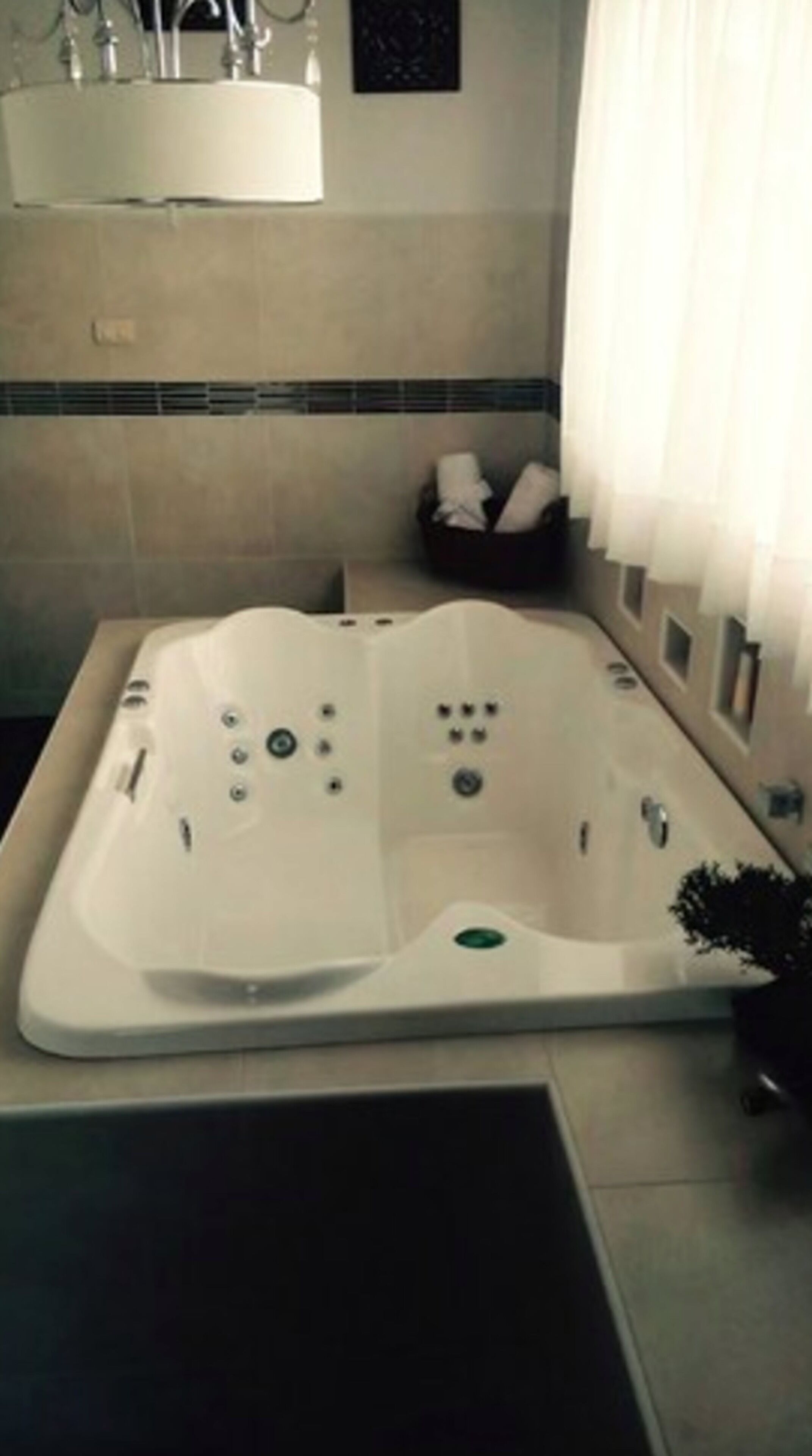 Une salle de bain moderne avec une baignoire sur pieds, un porte-serviettes et une petite poubelle.