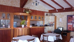Un restaurant avec des boiseries, un comptoir avec une machine à café et un mur orné d’un collage d’images.