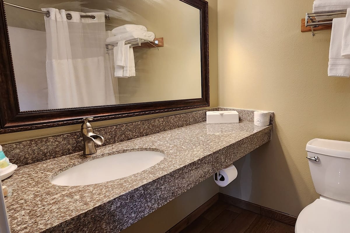 Een bad/douchecombinatie, handdoeken