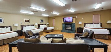 Habitación de hotel con dos camas, un sofá, un televisor y una chimenea.