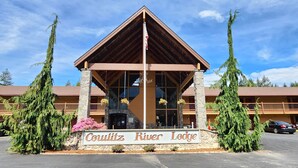 Una cabaña con una entrada destacada, pilares de piedra y un cartel que dice 'Coulitz River Lodge'.
