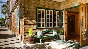 A wooden building with a green bench outside, a door labeled "107", and a sign for "Inn Country Inn".