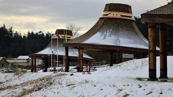 Un edificio cubierto de nieve con un diseño arquitectónico único, que presenta una estructura central grande y anexos más pequeños.