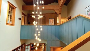 A multi-level interior with wooden beams, a staircase, and a hanging light fixture. - The La Conner Inn (La Conner)