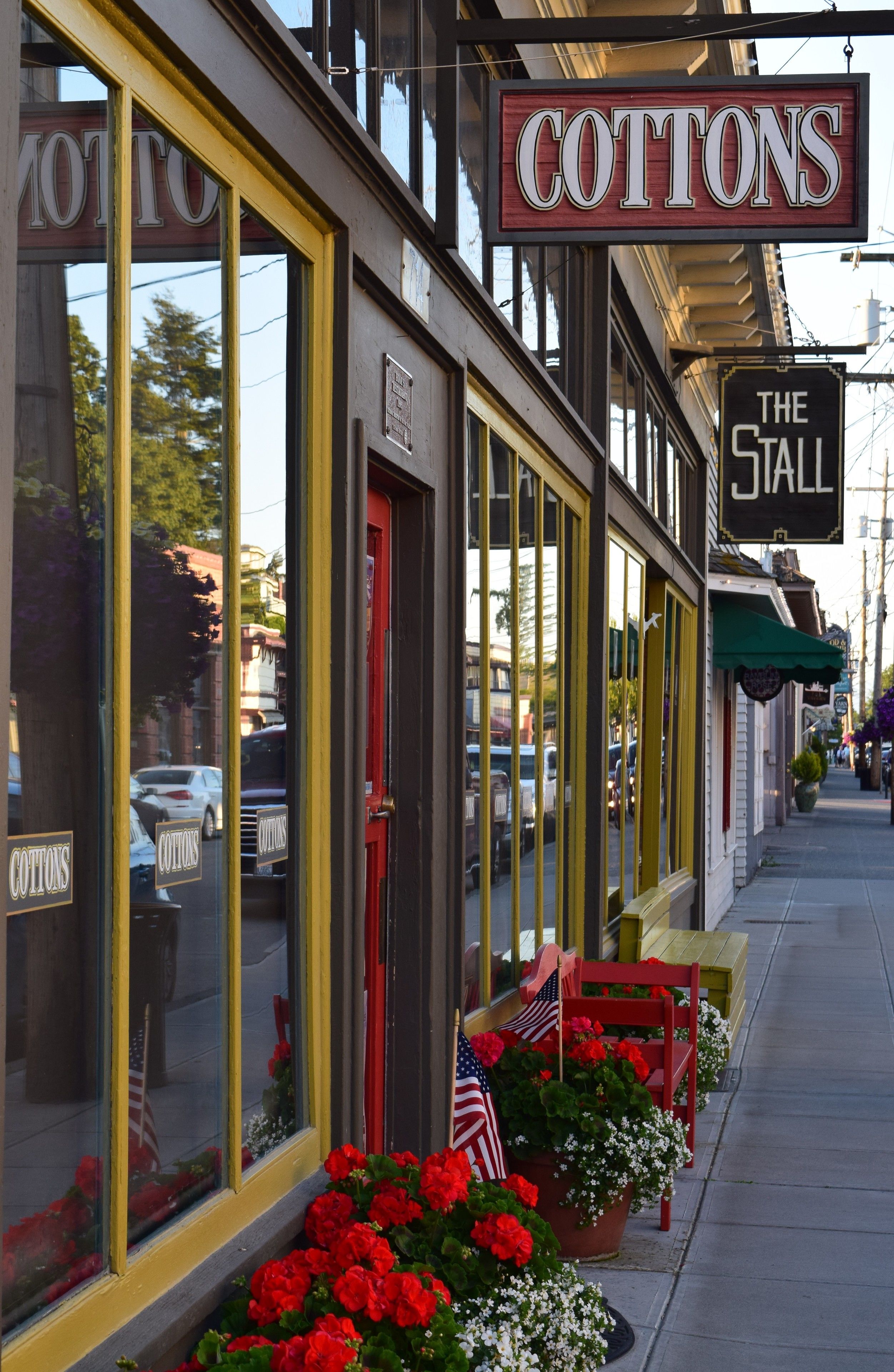 A storefront with a sign reading "COTTONS" and another sign for "THE STALL."