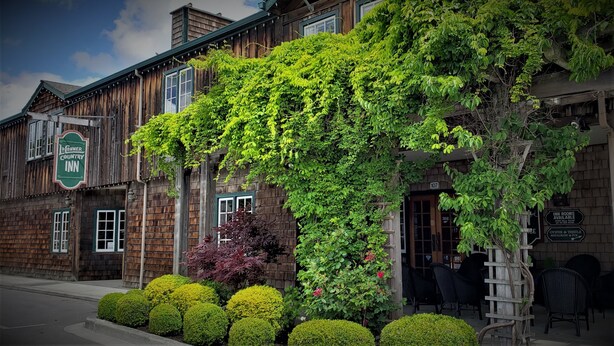 A rustic building with a sign for 'The Inn Country Inn' and a visible entrance door. - The La Conner Inn (La Conner)