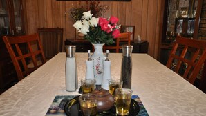 Una mesa de comedor con un florero, saleros, pimenteros y cuatro tazas de té.