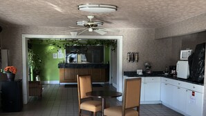 A modern kitchen with white cabinets, a black countertop, and a ceiling fan. - Western Inn (Union City)