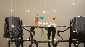 A table with two chairs, a drink, candles, and string lights. - Villa San Ignacio (Tambor)