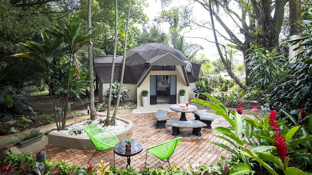 A patio area with outdoor seating and a small building with a sloped roof. - Villa San Ignacio (Tambor)