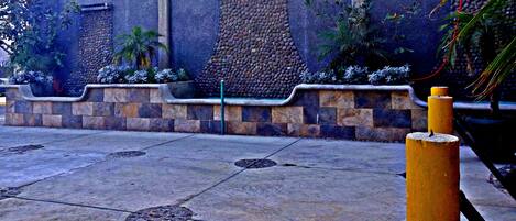 Un sendero pavimentado con escalones de piedra y un bolardo amarillo.