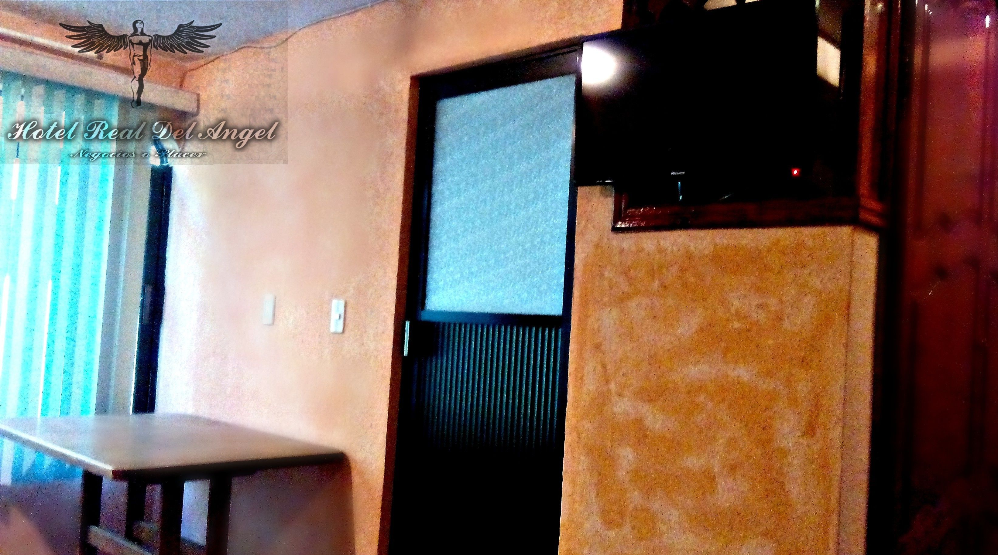 Una habitación de hotel con una cama, una mesita y una puerta que da a otra habitación.