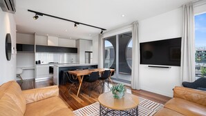 Un appartement moderne comprenant une cuisine, un coin repas et un salon.