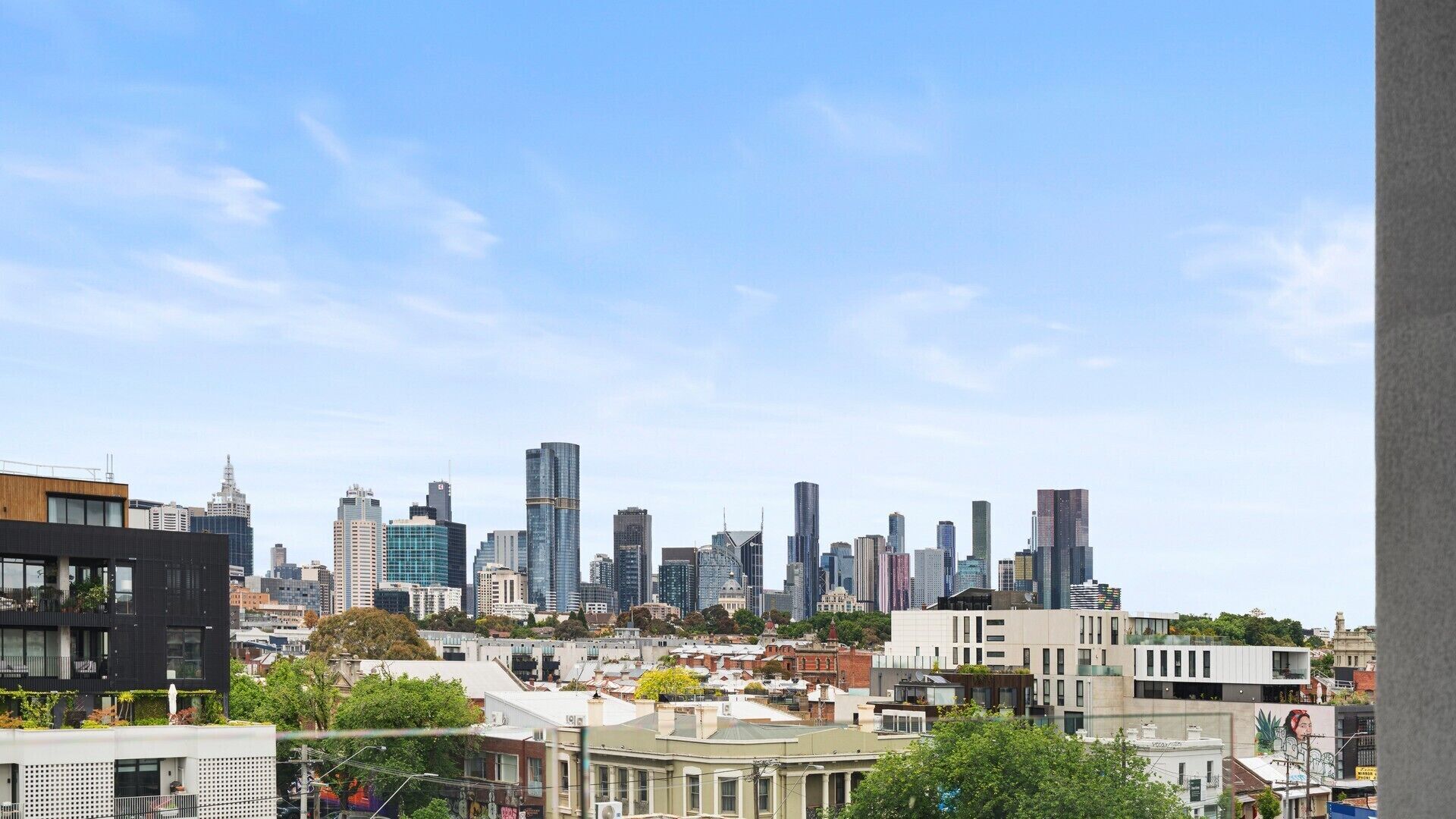 Une vue sur les toits d’une ville, avec des bâtiments modernes et un mélange de styles architecturaux.
