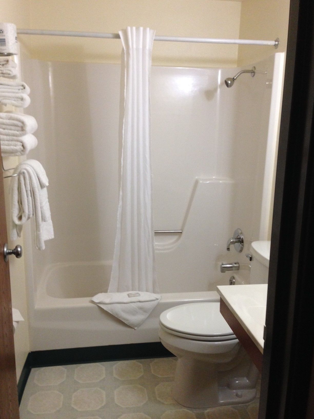 A bathroom with a bathtub, toilet, and a shower curtain.