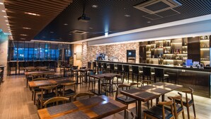 A modern restaurant with a brick wall, wooden tables, and a bar area. - IBC Hotel (Seoul)