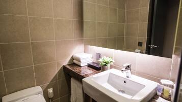 Un baño moderno con un lavamanos blanco, un espejo y un inodoro.
