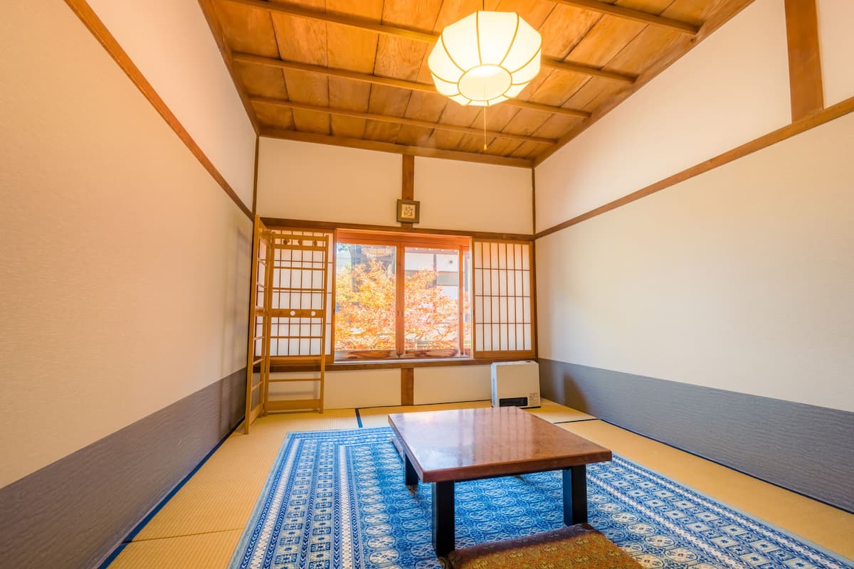 A traditional Japanese room with tatami flooring, a low wooden table, and shoji screens.