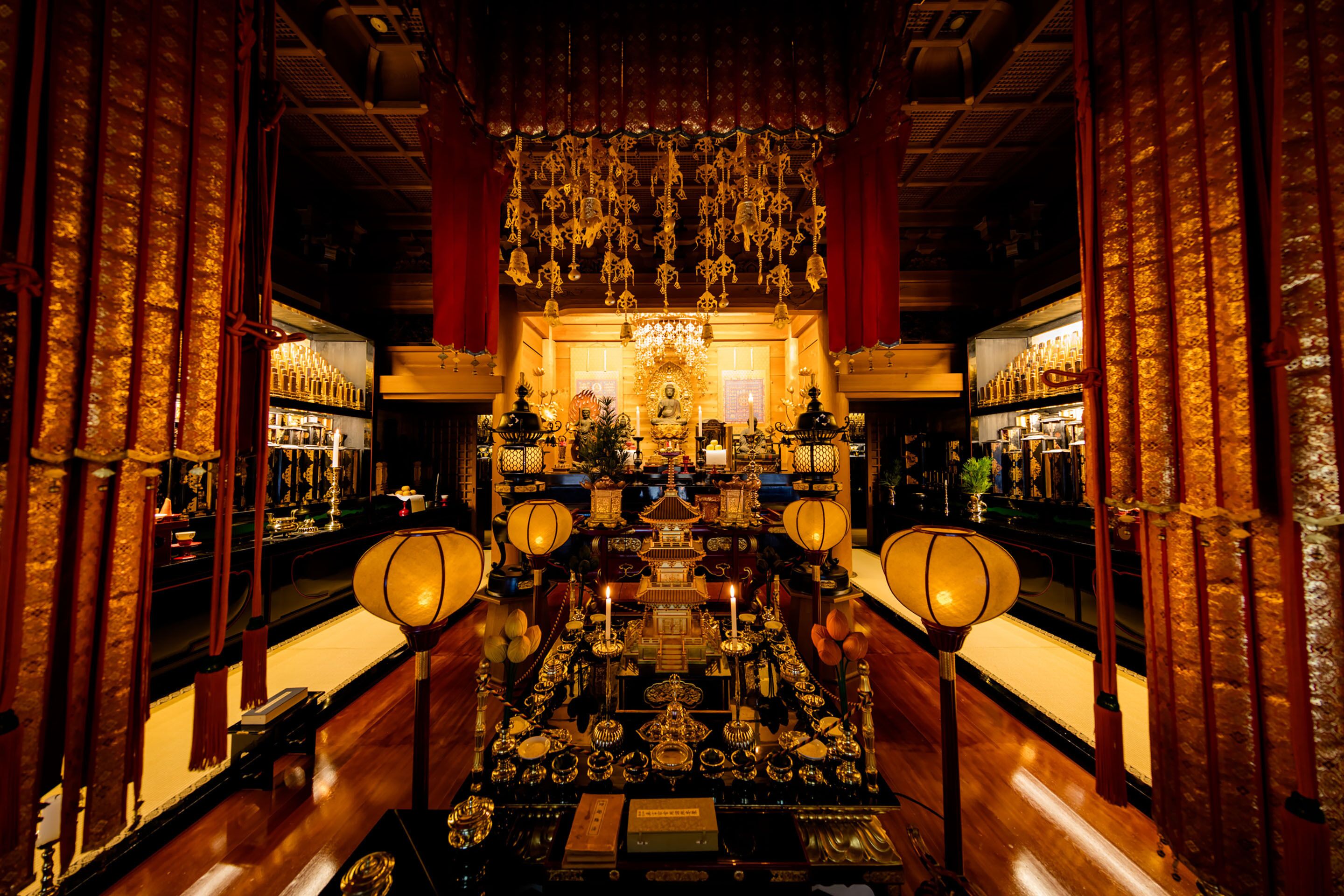 An ornate room with a central altar, red curtains, and hanging decorations.