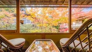 A traditional Japanese room with tatami flooring, a low table, and two tatami chairs.