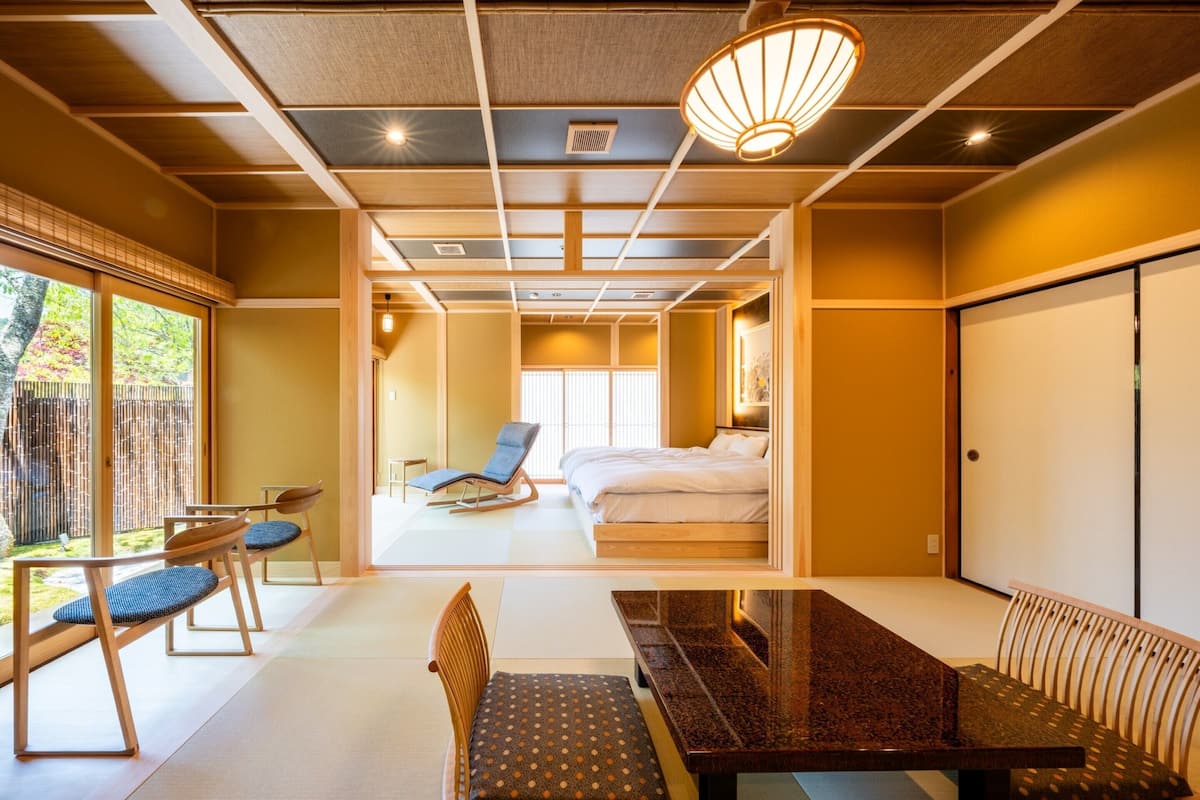 A traditional Japanese-style room with tatami flooring, a low table, and a seating area.