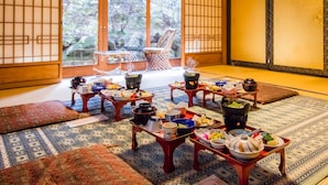 A traditional Japanese room with tatami mats, shoji screens, and a view of a garden.