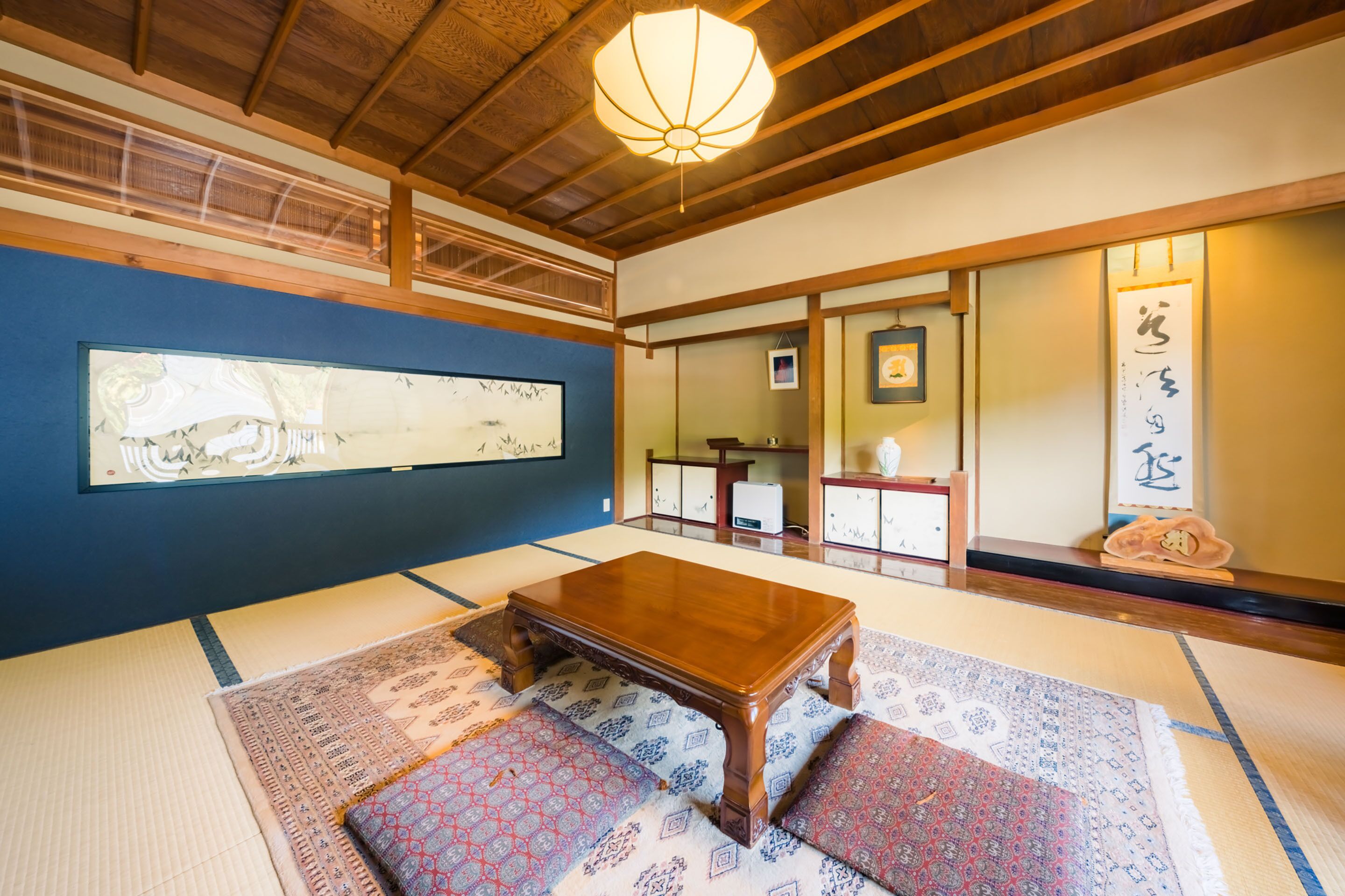 A traditional Japanese room with tatami flooring, a wooden table, and shoji screens.