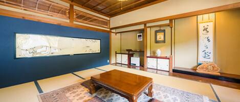 A traditional Japanese room with tatami flooring, a wooden table, and shoji screens.