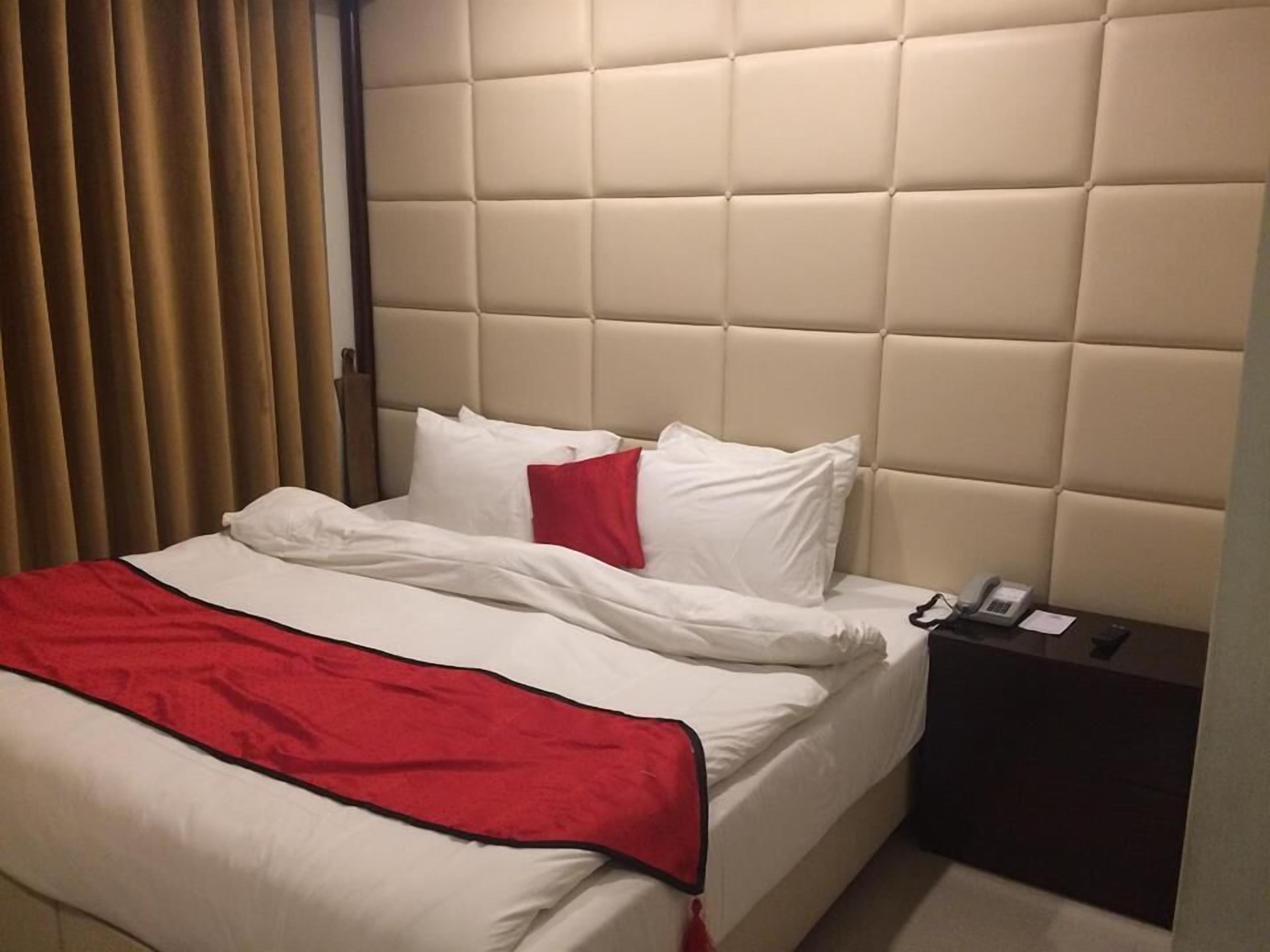 Ein Hotelzimmer mit einem Bett, einem Nachttisch und einem Telefon.